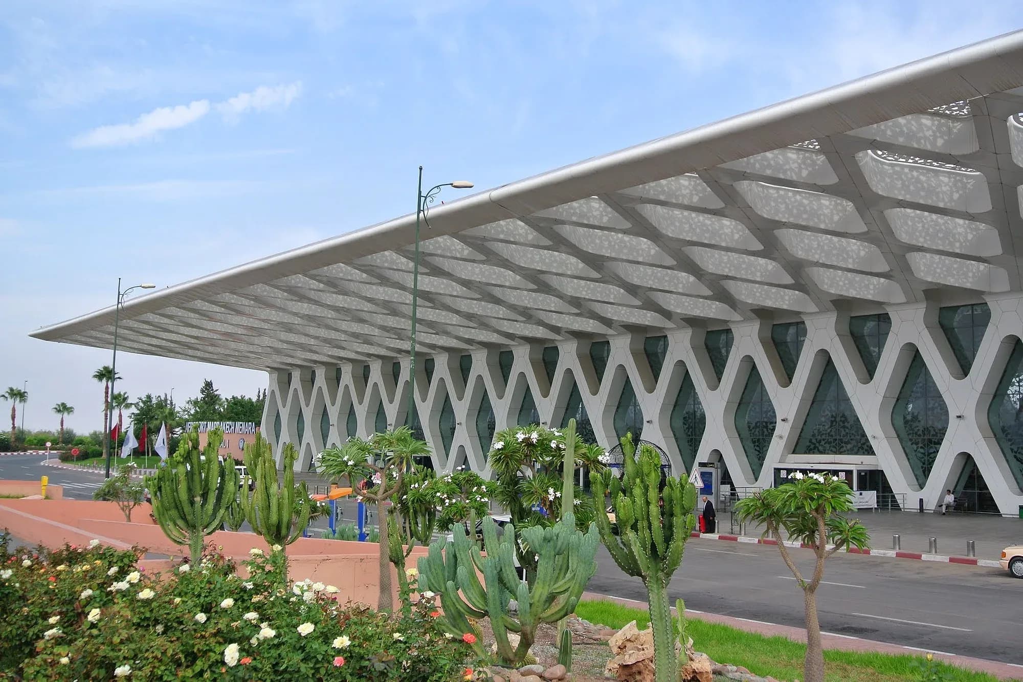 Terminal del aeropuerto Marrakech-Menara con su celosía blanca y jardín de cactus