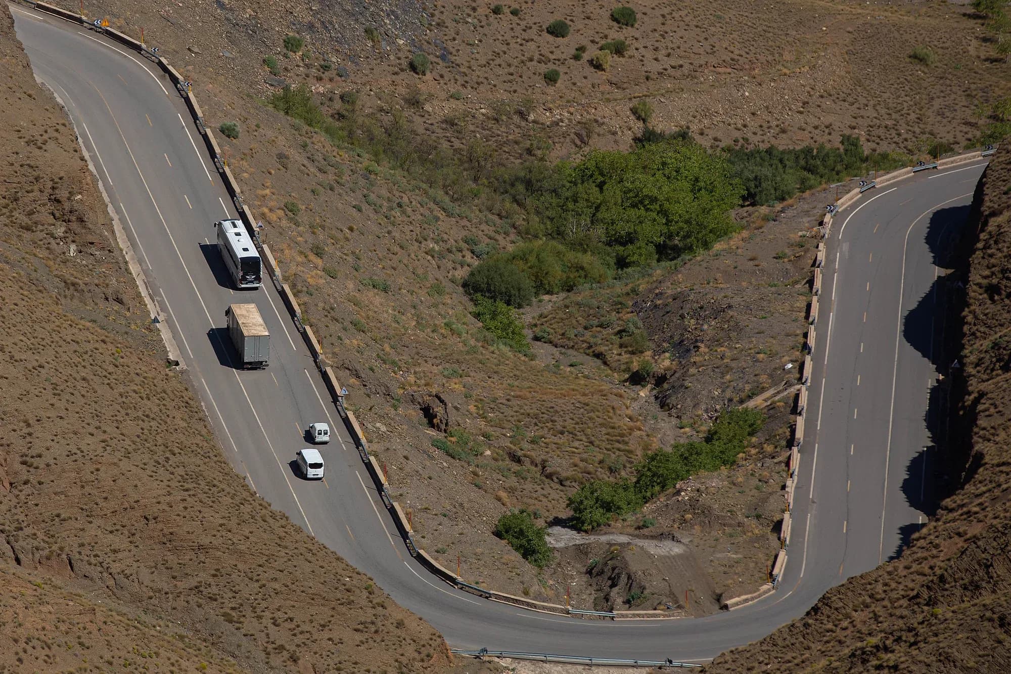 Autocar y coches en una curva cerrada de la carretera del Tizi n'Tichka