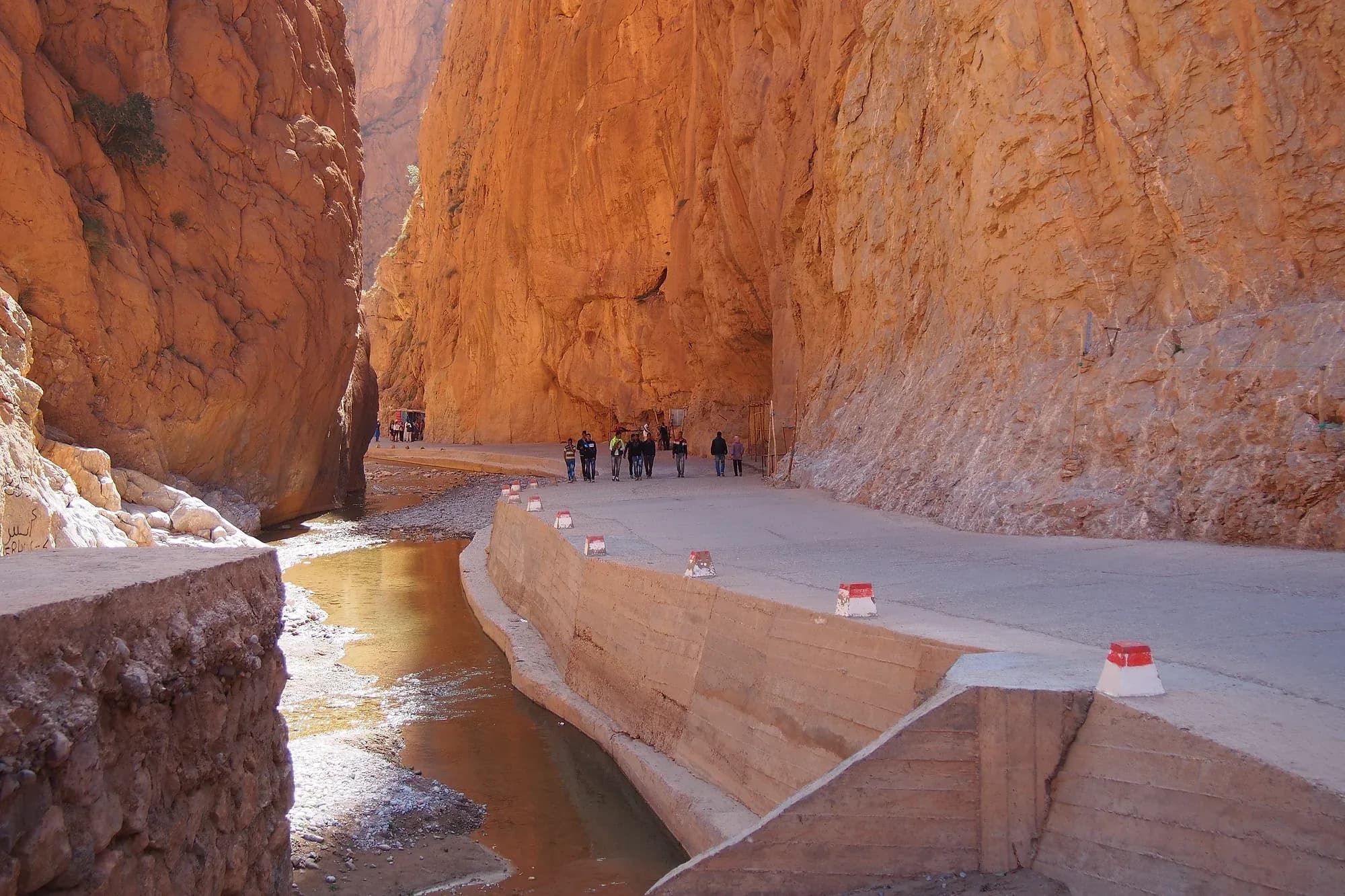 Sheer rock walls in the narrowest stretch of the Todra Gorge, with visitors in the distance