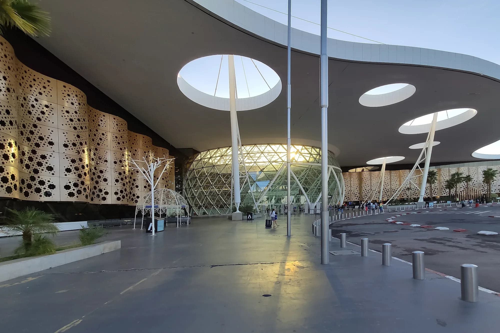 Entrance of the Marrakech-Menara airport terminal with its latticed facade and white roof