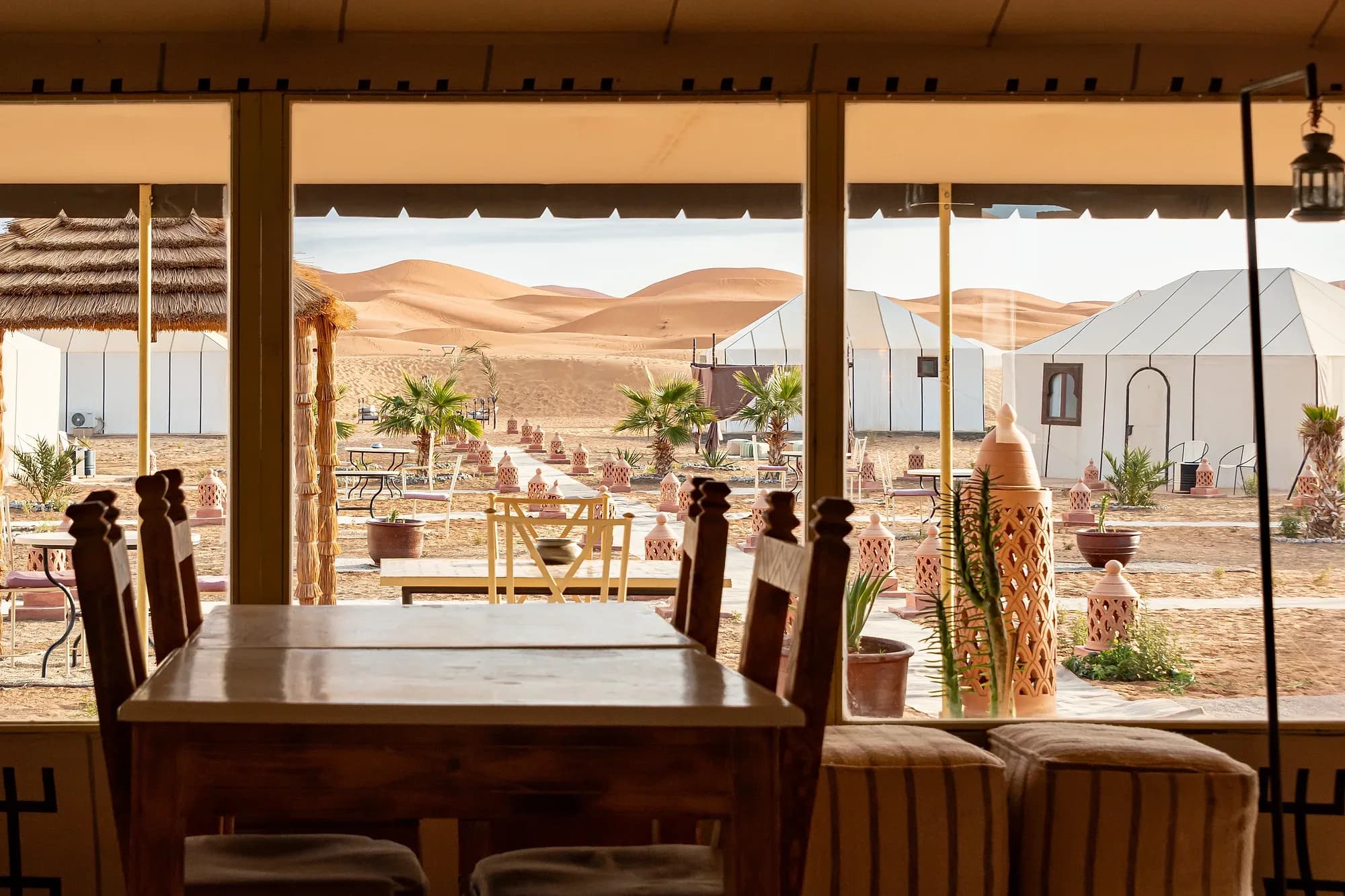 Comedor de un campamento de jaimas blancas frente a las dunas de Erg Chebbi