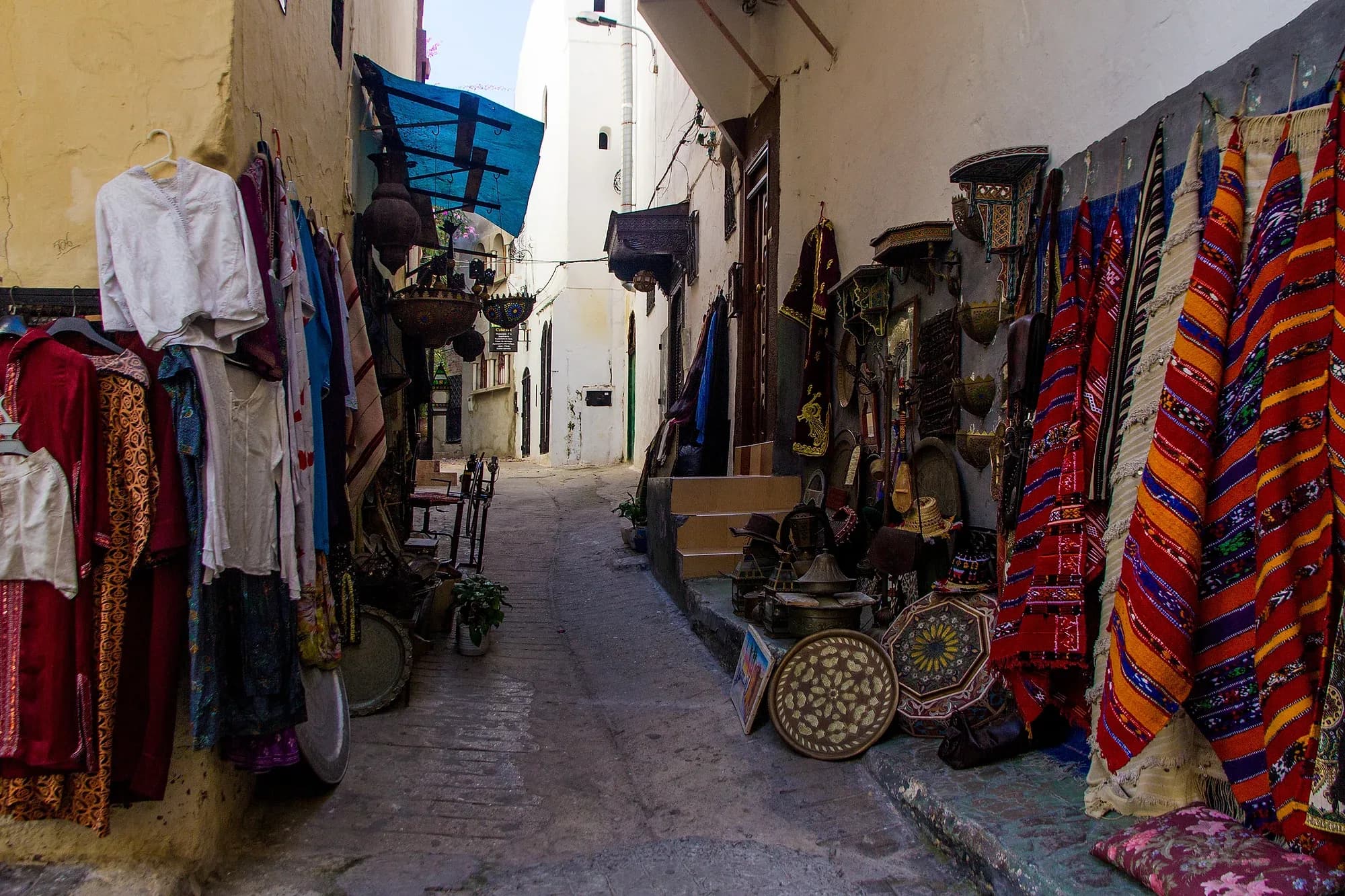 Callejuela de la medina de Tánger con tiendas de alfombras, telas y artesanía