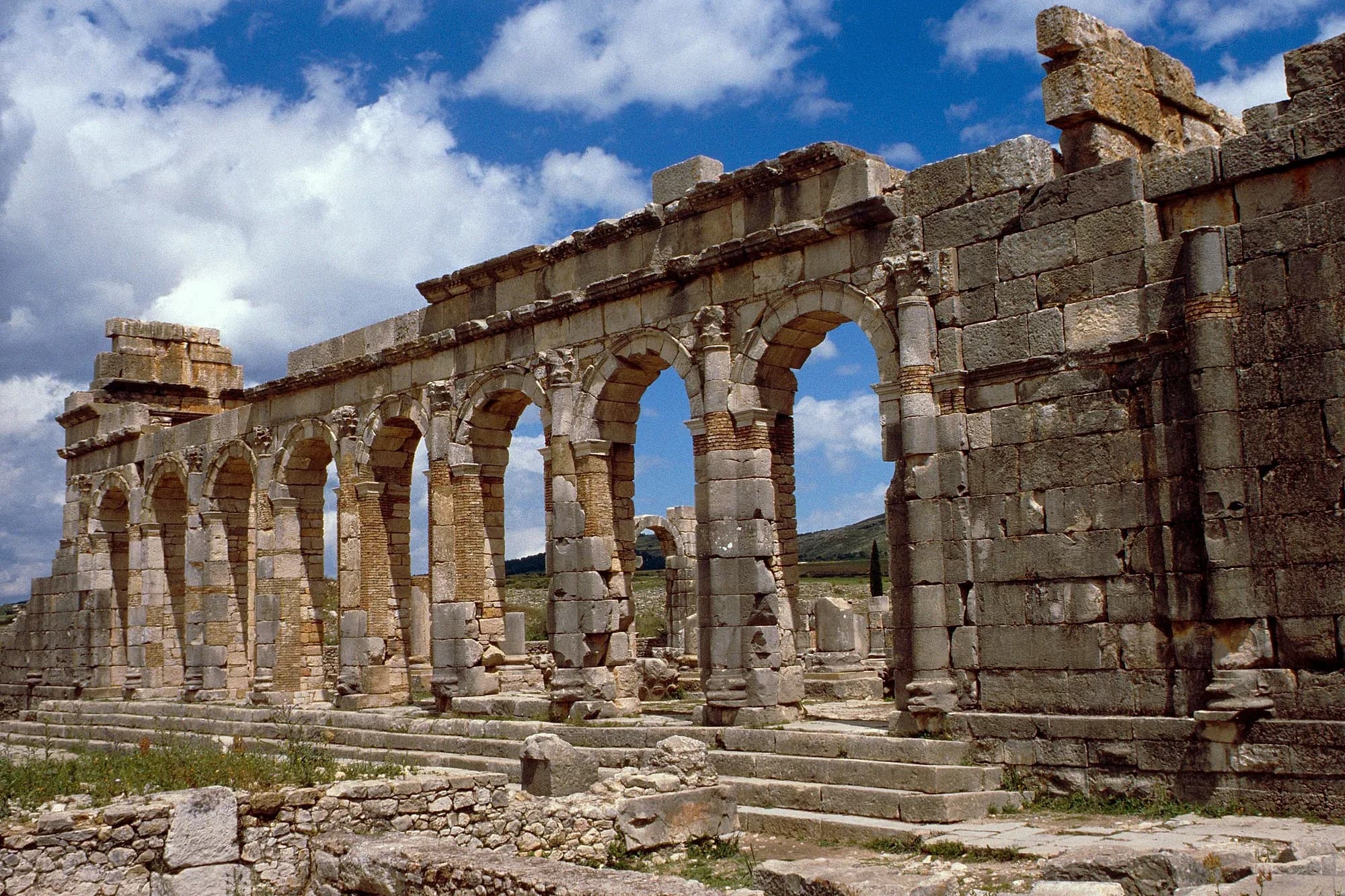 Arcades of the Roman basilica of Volubilis under a cloudy sky