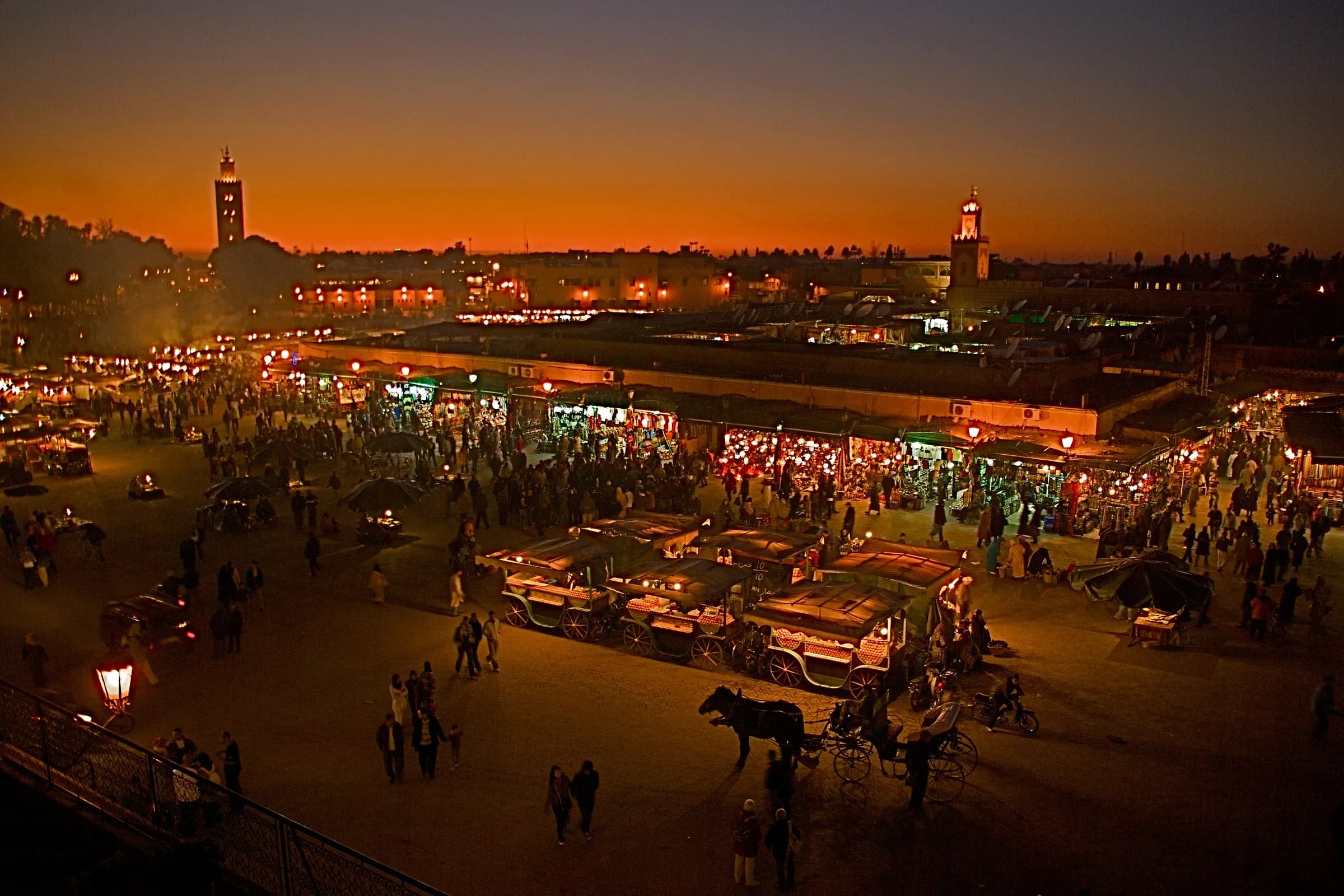 Jemaa el-Fna square at dusk with food stalls and the Koutoubia minaret, Marrakech