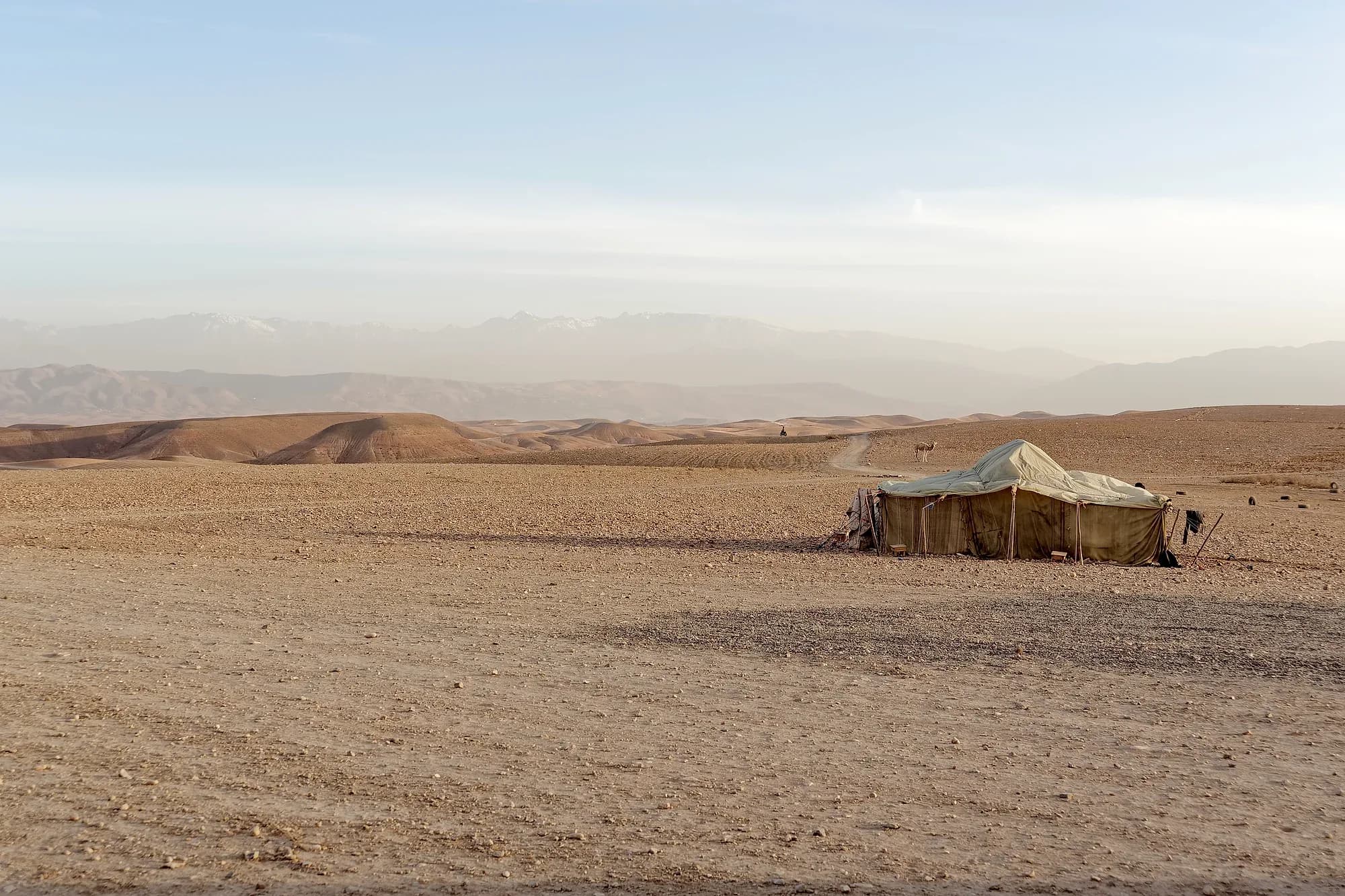 Berber tent in the stony Agafay Desert with the High Atlas behind, near Marrakech